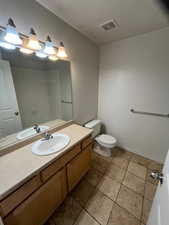 Bathroom with tile patterned flooring, vanity, and toilet