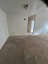 Spare room featuring light carpet and a textured ceiling