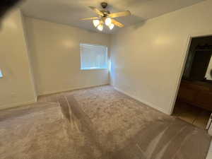 Carpeted spare room with ceiling fan