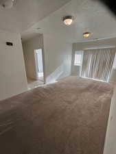 Carpeted empty room featuring a textured ceiling