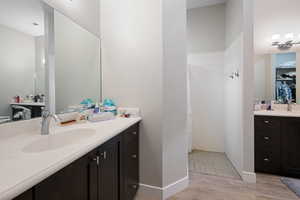 Bathroom featuring a shower, hardwood / wood-style floors, and vanity