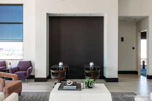 Living area with baseboards, a healthy amount of sunlight, and an accent wall