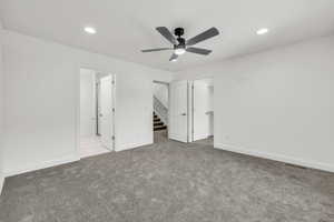 Unfurnished bedroom featuring carpet floors, baseboards, visible vents, and a walk in closet