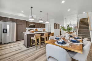 Dining area with light wood-style floors, stairway, and recessed lighting