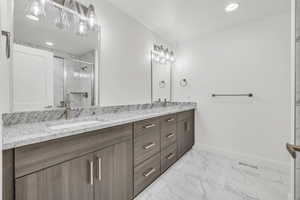 Bathroom with a sink, visible vents, baseboards, marble finish floor, and a marble finish shower