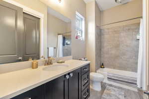 Full bathroom with shower / bath combo, toilet, and vanity