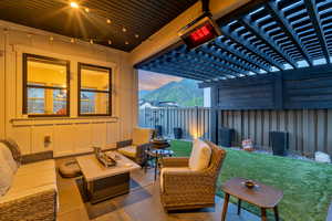 Patio terrace at dusk featuring a mountain view, an outdoor hangout area, and a yard