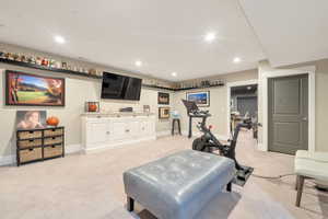 Exercise room featuring light colored carpet and bar area