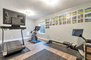 Exercise area featuring hardwood / wood-style floors and a textured ceiling