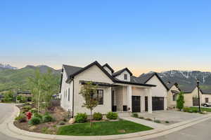 View of front of home with a mountain view and a garage