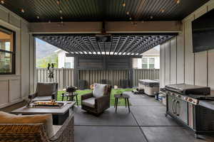 View of patio / terrace featuring a mountain view, a hot tub, and an outdoor fire pit