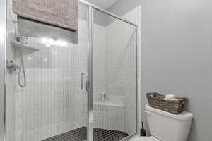 Bathroom with a shower with shower door and toilet