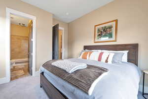 Bedroom with light colored carpet and ensuite bath