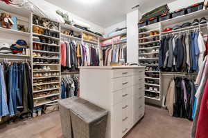 Spacious closet featuring light colored carpet