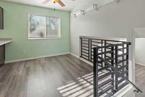 Unfurnished dining area with ceiling fan, dark wood-type flooring, and lofted ceiling