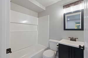 Full bathroom featuring shower / tub combination, vanity, and toilet