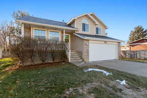 View of front of home featuring a front yard and a garage