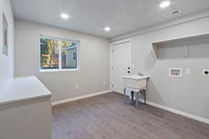 Laundry room with washer hookup, electric dryer hookup, and hardwood / wood-style flooring