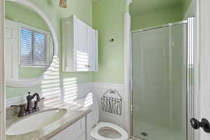 Bathroom with vanity, toilet, and a shower with door