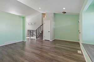 Unfurnished room featuring lofted ceiling and dark hardwood / wood-style floors