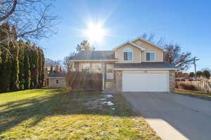 Tri-level home with a front lawn and a garage