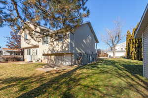 Back of house featuring central AC and a yard