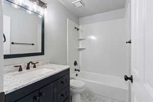 Full bathroom featuring shower / washtub combination, vanity, a textured ceiling, and toilet