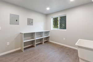 Unfurnished bedroom featuring electric panel and light hardwood / wood-style floors