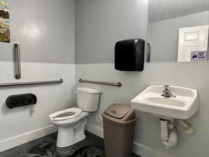 Bathroom featuring concrete floors and toilet