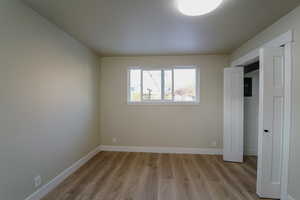 Unfurnished bedroom featuring light hardwood / wood-style floors and a closet