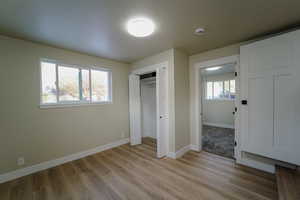 Unfurnished bedroom featuring light wood-type flooring and a closet