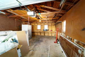 Garage featuring white refrigerator and a garage door opener