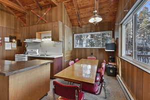 Kitchen with vaulted ceiling with beams, white electric range oven, wood ceiling, and a baseboard heating unit