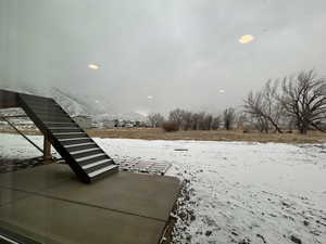 View of yard layered in snow. You even have a mtn view from the basement!