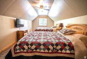 Carpeted bedroom with ceiling fan and vaulted ceiling