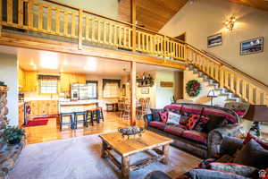 Carpeted living room featuring high vaulted ceiling and wood ceiling