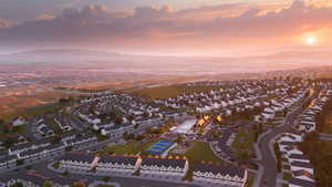 Aerial view at dusk featuring a water and mountain view