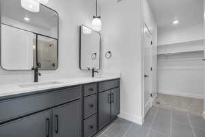 Bathroom featuring vanity, tile patterned flooring, and a shower with door