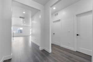 Hallway with dark hardwood / wood-style flooring