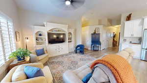 Living room with a wealth of natural light, ceiling fan, and light wood-type flooring