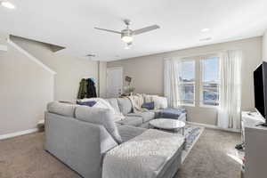 Living room featuring ceiling fan and light colored carpet