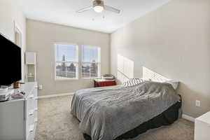 Carpeted bedroom featuring ceiling fan