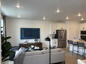 Living room featuring a textured ceiling and hardwood / wood-style flooring