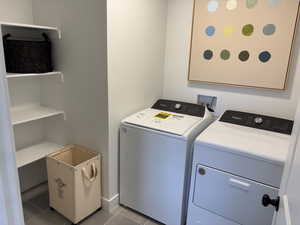 Clothes washing area with washing machine and clothes dryer and light tile patterned floors