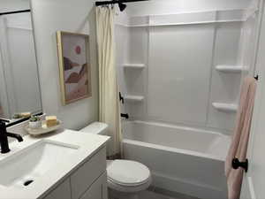 Full bathroom featuring shower / tub combo with curtain, vanity, and toilet