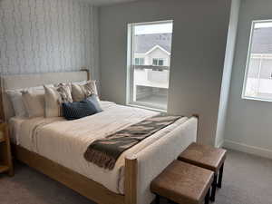 Carpeted bedroom featuring multiple windows