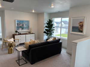 Living room featuring plenty of natural light, light colored carpet, and a textured ceiling