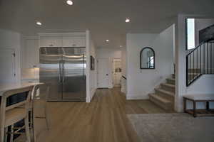 Kitchen featuring white cabinetry, built in refrigerator, and light hardwood / wood-style floors