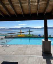 View of swimming pool with a patio area and a water and mountain view