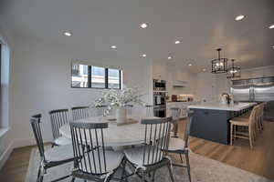 Dining room featuring sink, dark wood-type flooring, and an inviting chandelier